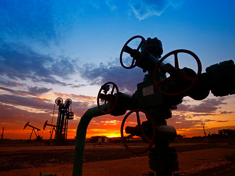 Oilfield pipeline silhouette at sunset